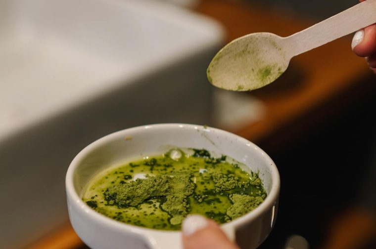 A person prepares matcha tea in a modern bathroom, capturing a calming home ritual.