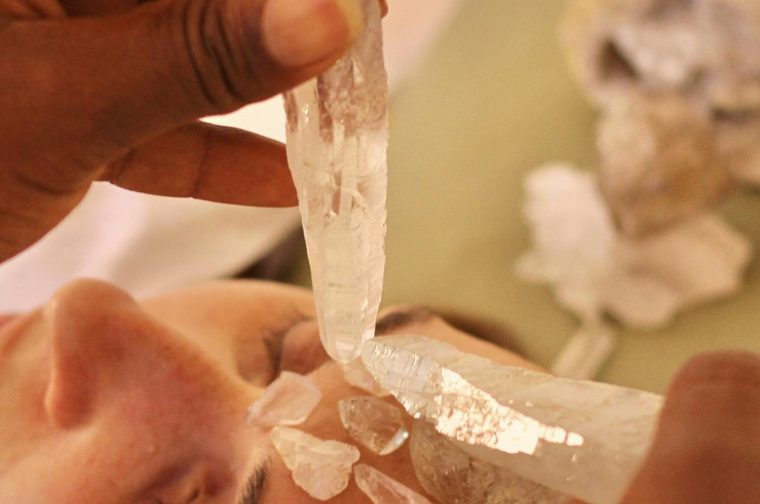 Close-up of crystal therapy for healing and wellbeing, focusing on the forehead.